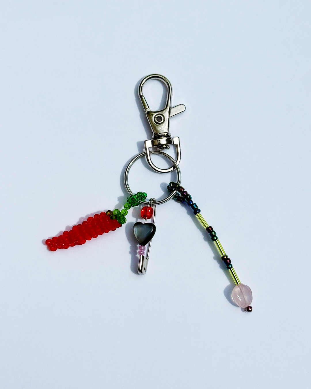 Chili keychain with a pin and a small black mother-of-pearl heart