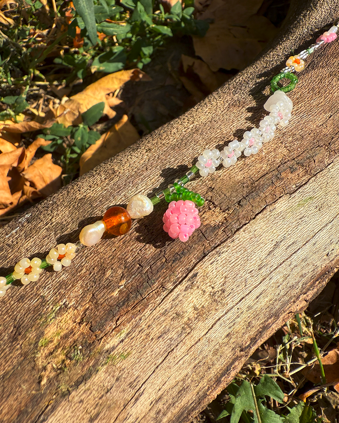 Colorful beaded bracelet with floral designs on a wooden surface