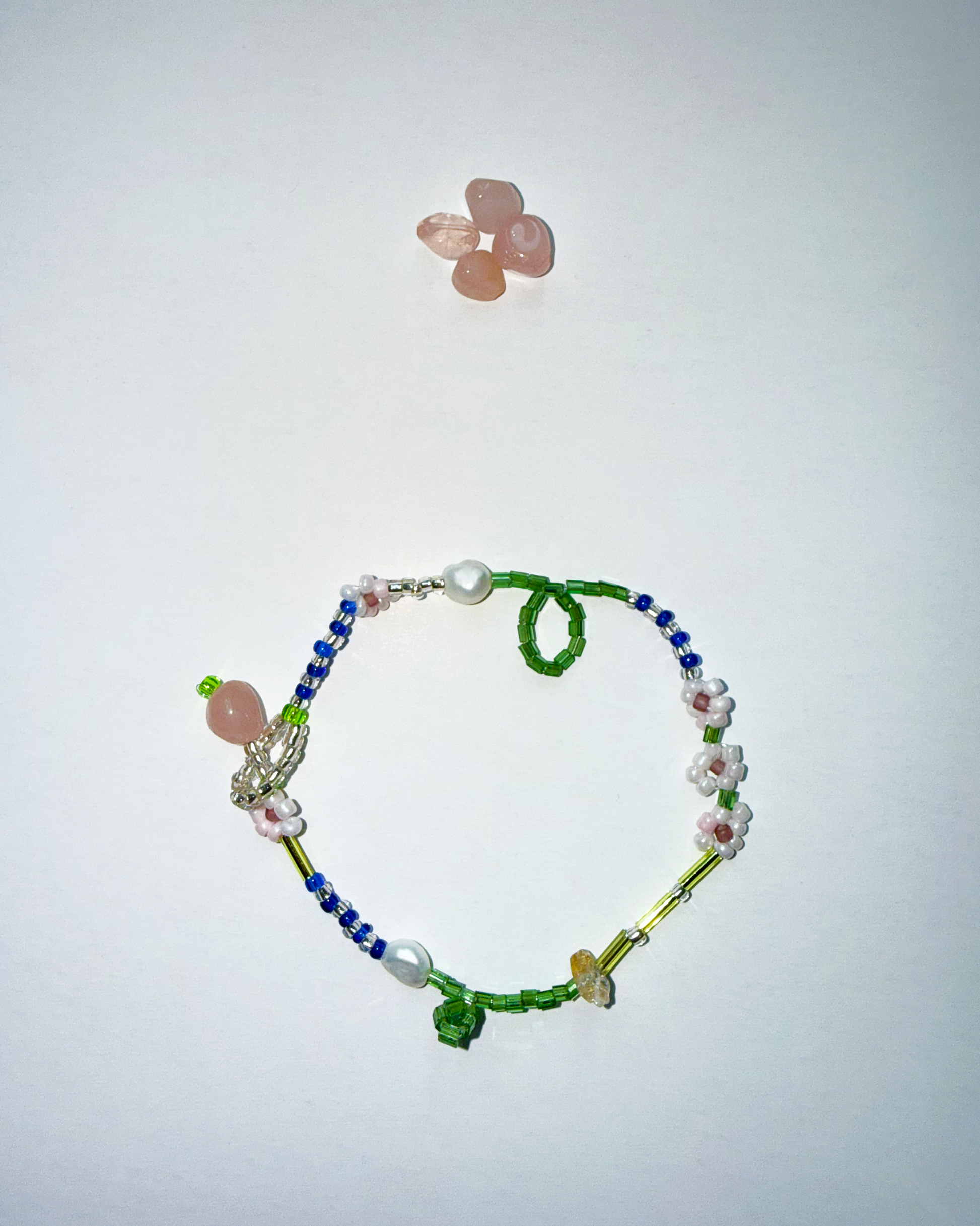 Bracelet with floral and green design on a light  background with pink quartz