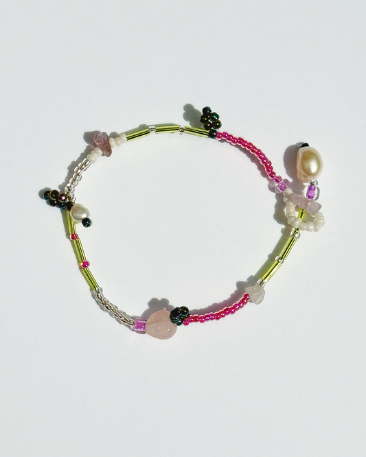 Colourful beaded bracelet on a white background with pearls and pink quartz