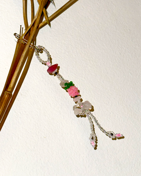Beaded pin with floral elements on a white background