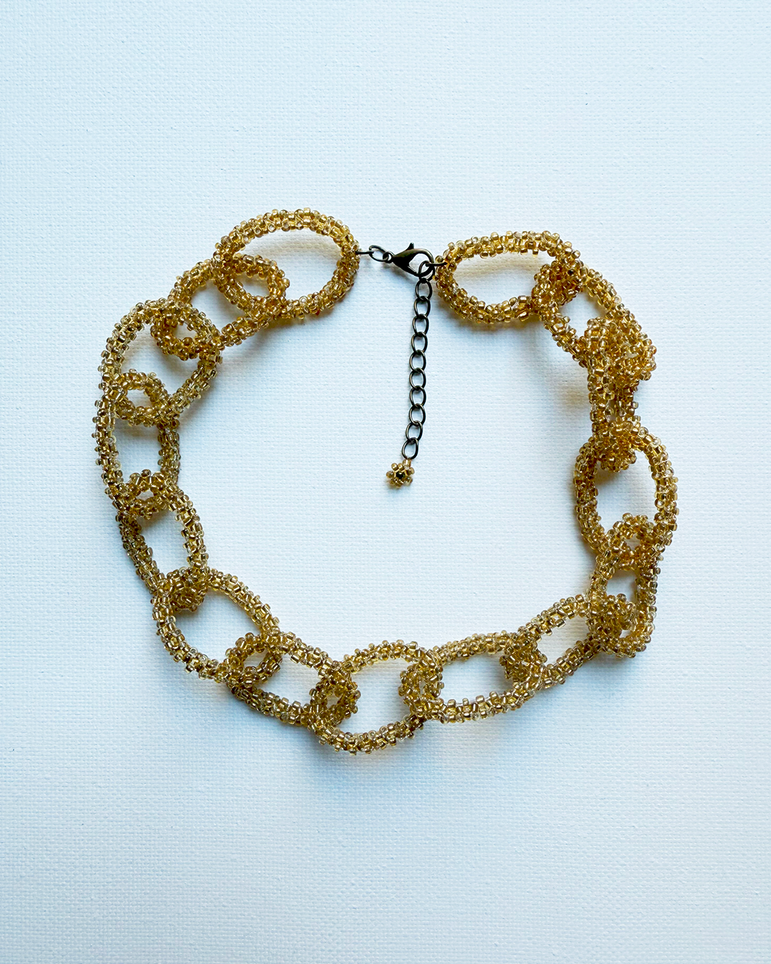 Gold chain necklace on a light blue background