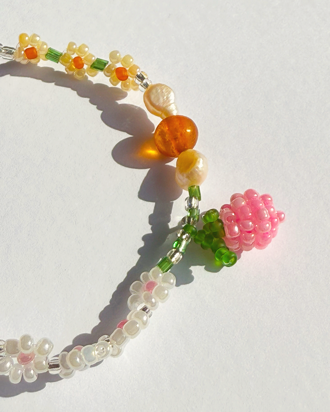 Colorful beaded bracelet with various beads on a white background