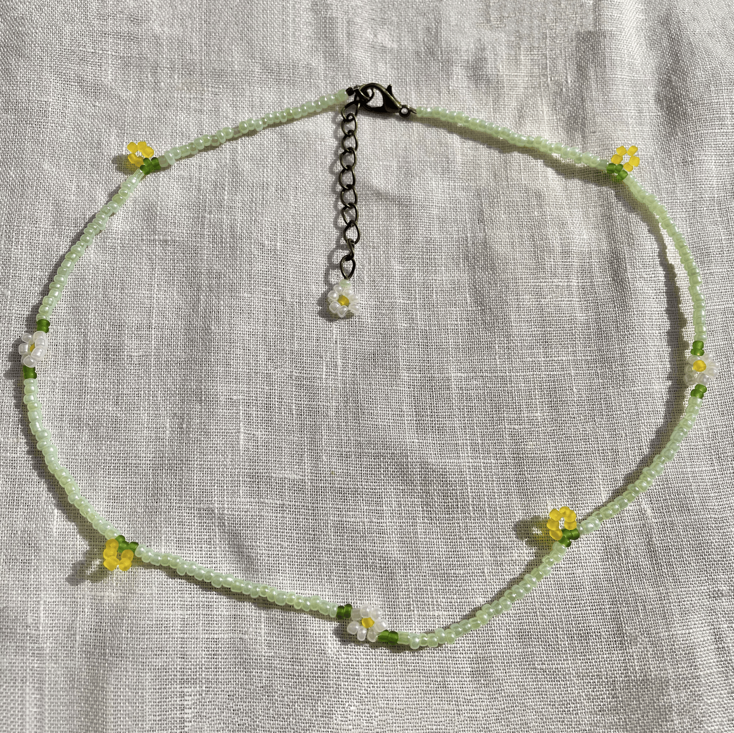 Necklace with floral beads on a textured fabric background