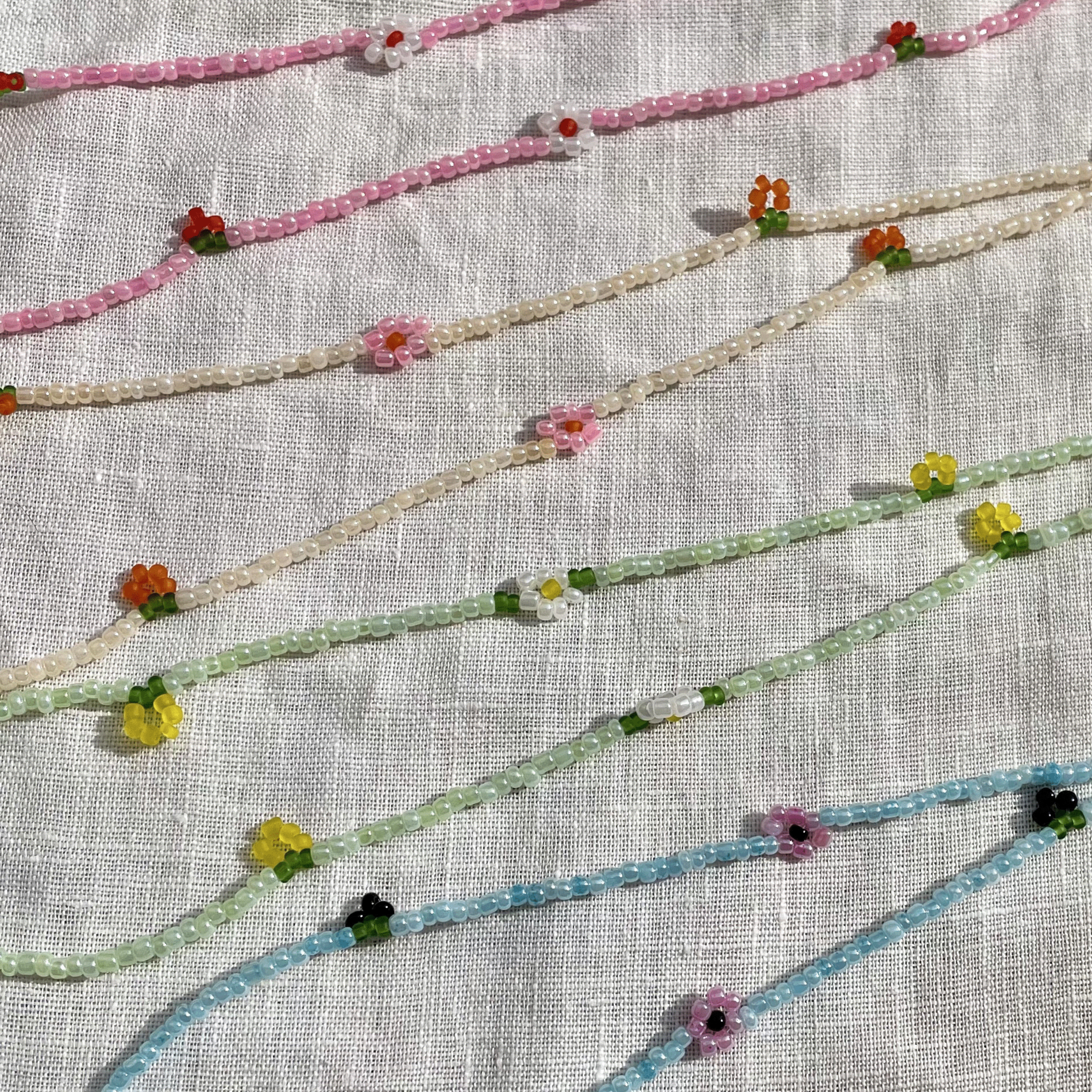 Set of beaded necklaces on a textured fabric background